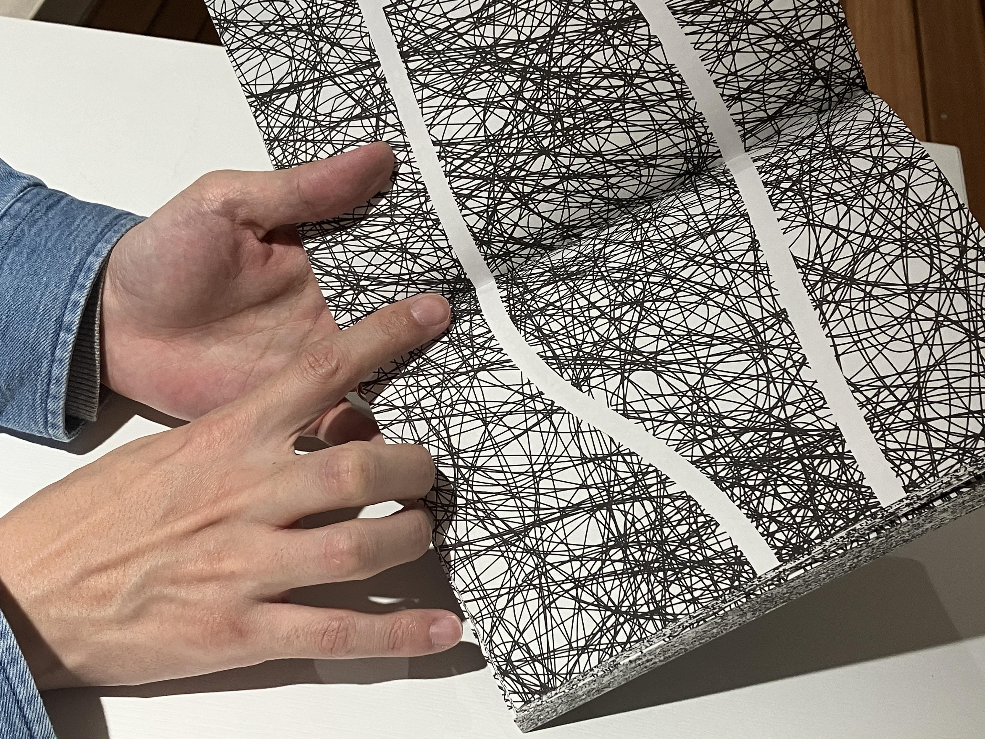 ノートの綴じ部で白い線がずれることがないように調整