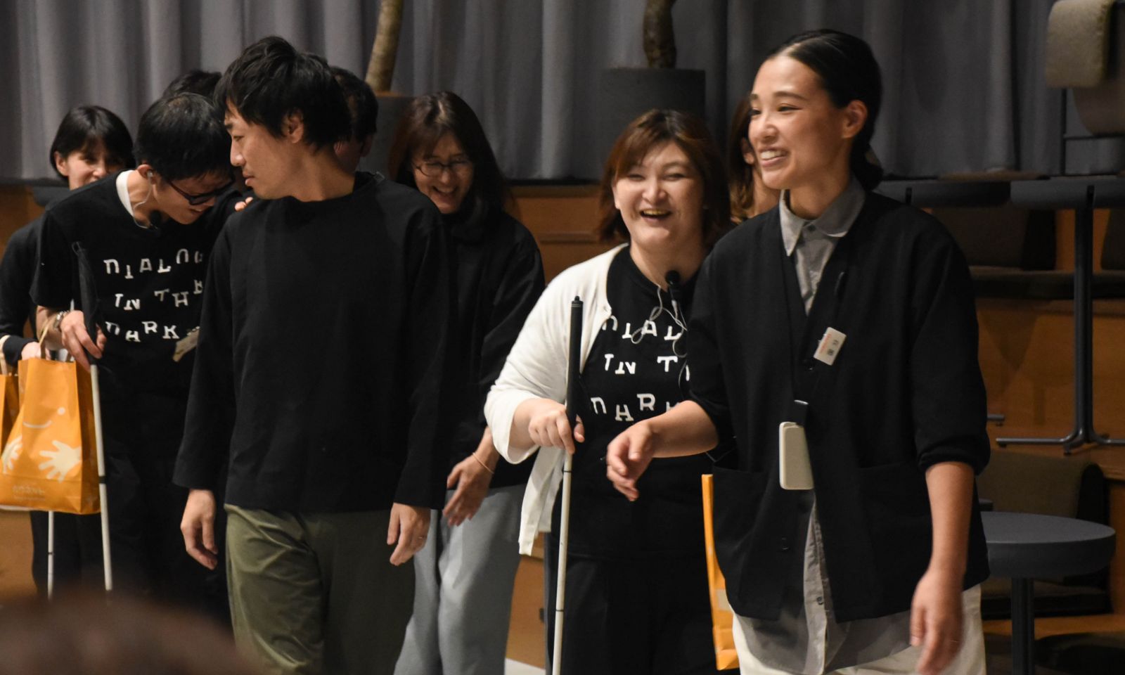 視覚障がいのあるアテンダーが白杖を使いながら、先導するコクヨ社員の肘を持っている