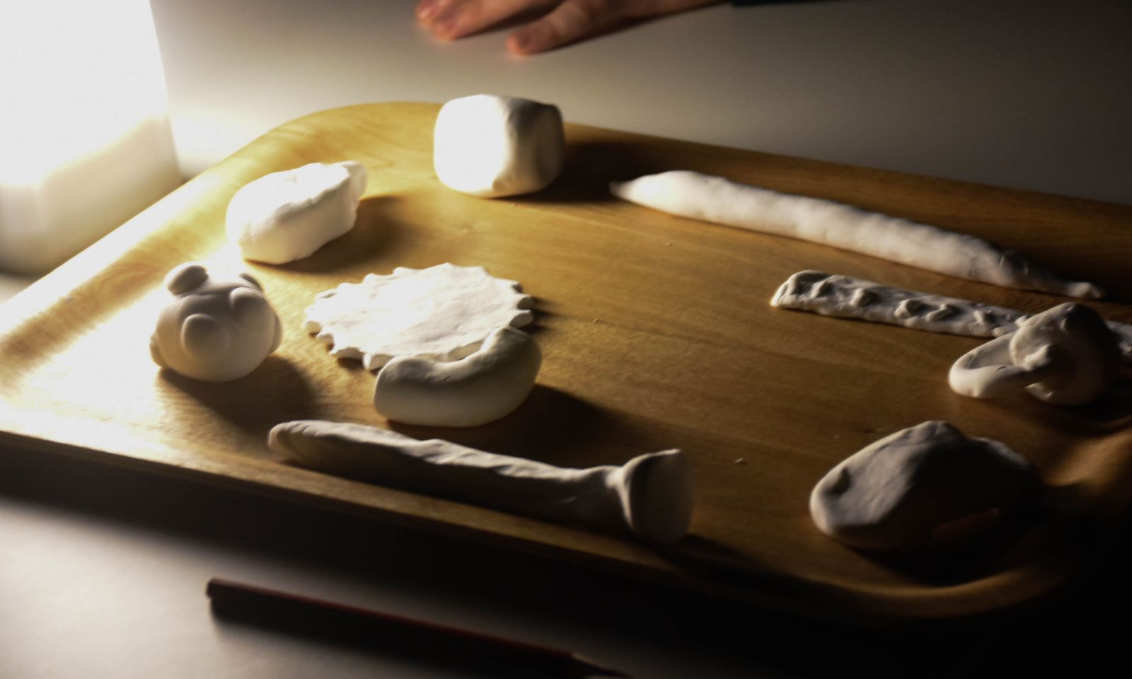 暗闇の中でつくった粘土の作品のアップ画像。スタンドライトの薄明るい光に照らされている