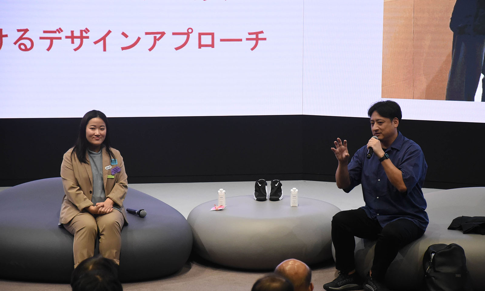 イベントに登壇し、トークセッションで話す黒田英邦と、その隣で微笑みながらトークを聞いている田中美咲さん