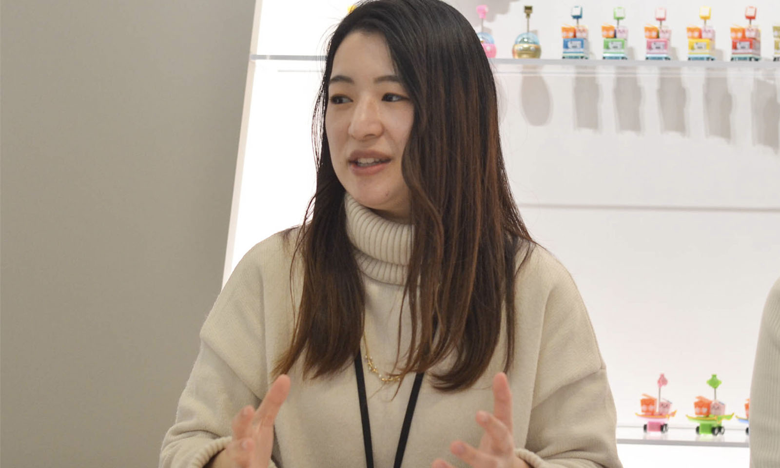 白いセーターを着たカウネット商品開発の小原（おはら）さんが、笑顔でリリース後の反応について話す様子