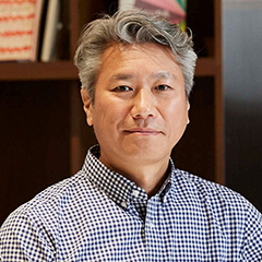 襟付きのシャツを着て微笑む越川康成さんのプロフィール写真