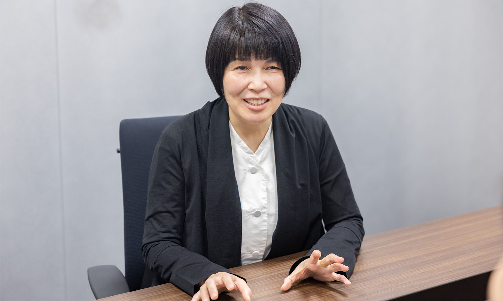 黒いジャケットを着てインタビューに答える栗木さん