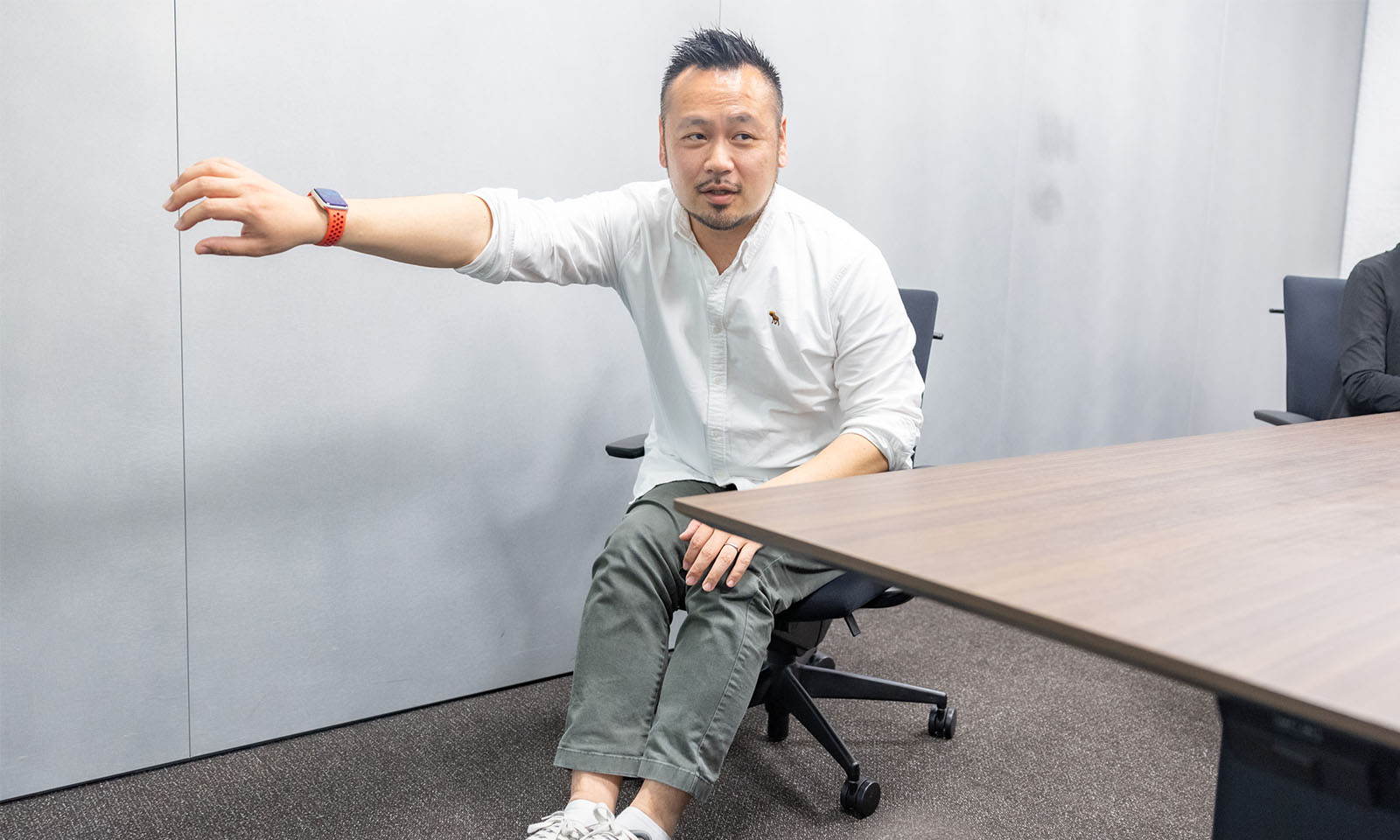 オフィスチェアーに座ったまま、引き戸を引く様子を再現する武田さん