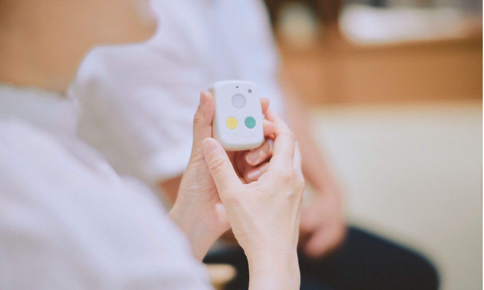 <ALT始まり>はろここトークのアップ。手のひらサイズの四角いボディに、３つのボタンが三角形の配置でつけられている。上のボタンは白、左下は黄色、右下は緑色。<ALT終わり>