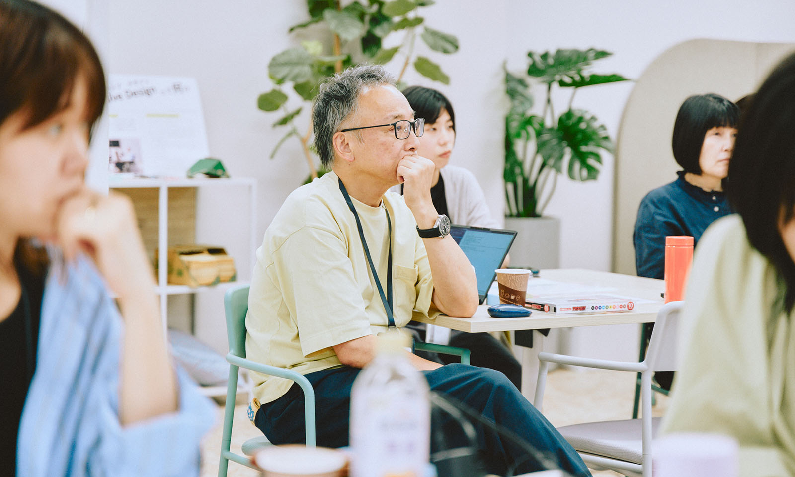 ALTはじまり。真剣に説明を聞いているコクヨの皆さんの写真。中心には椅子に座り、眼鏡をかけていて、白髪のショートカットのコクヨの井田さんが話し手をみつめている。ALTおわり。