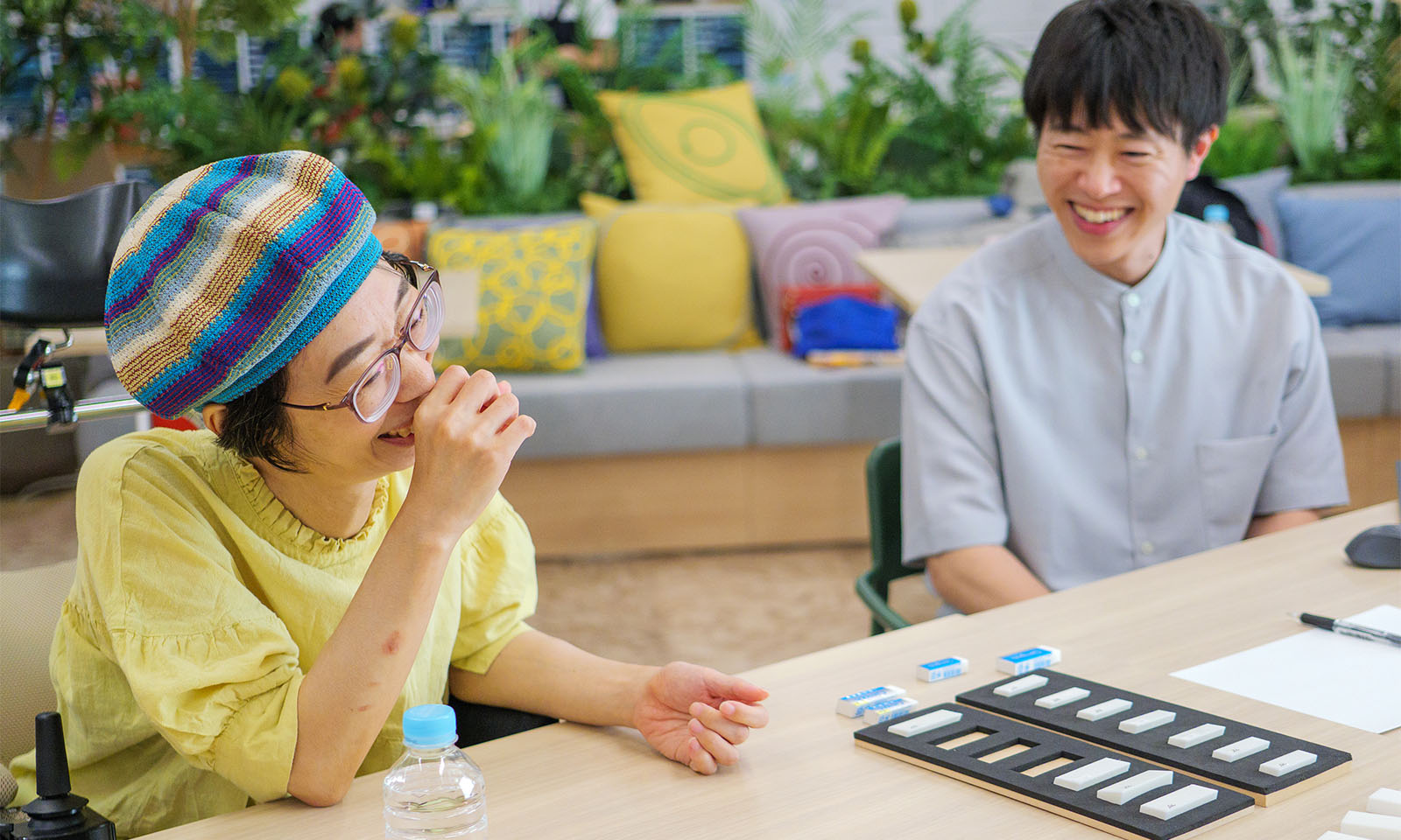 <ALT始まり>ワークショップで検証したプロトタイプを前に、笑顔で会話する吉岡さんと波子さん。<ALT終わり>