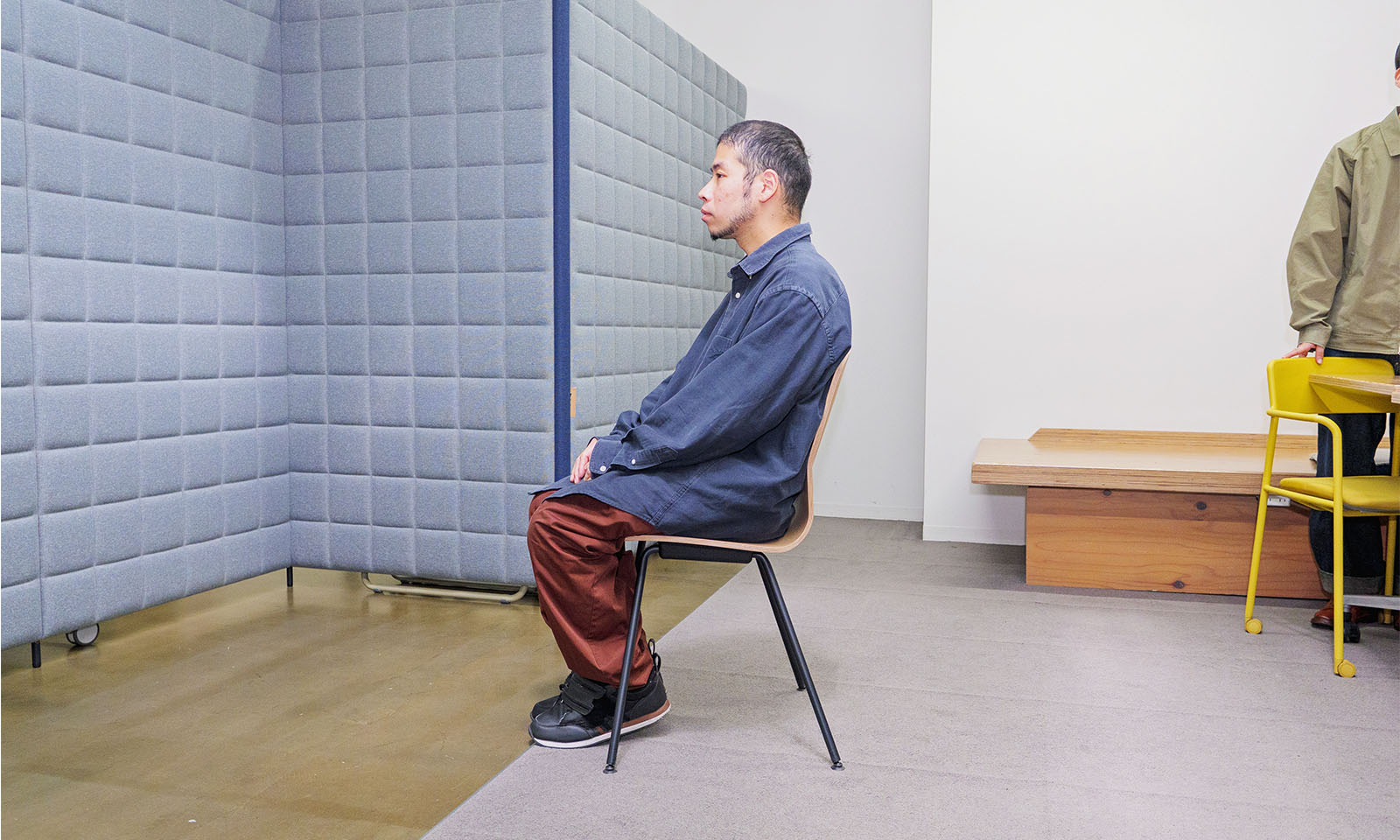 ALTはじまり。イスに座ったリードユーザーの東埜さんを真横から見たもの。手は膝の上でそろえて真っすぐに前を向き、背筋を伸ばした状態で座面の奥深くまでしっかりと腰掛けている。ALTおわり。