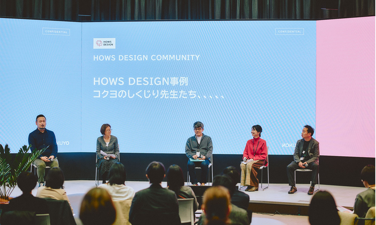 （ALT始まり）スクリーンの前に座る5名のコクヨ社員の登壇者たち。男女年齢は様々で、服装はカジュアルな人が多い。スクリーンには「ハウズデザイン事例　コクヨのしくじり先生たち」という文字が表示されている（ALT終わり）
