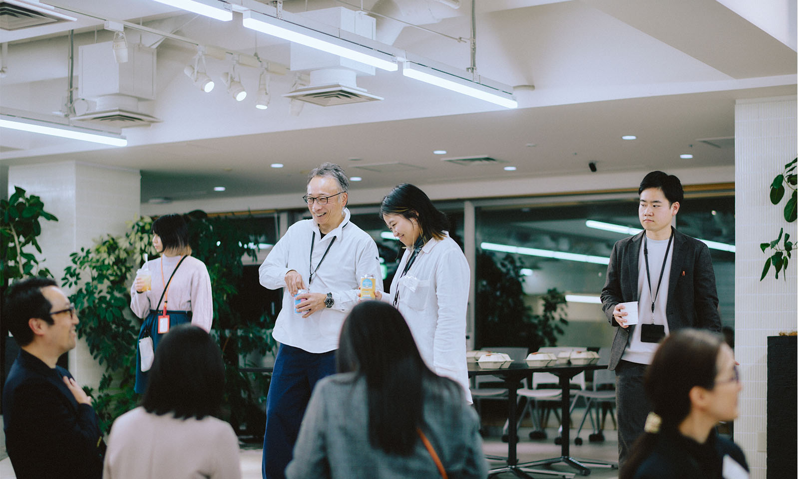 （ALT始まり）笑い合う参加者たち。イベント中とは会場の雰囲気も変わり、明るく開放感のあるオフィス空間で話をしている。（ALT終わり）
