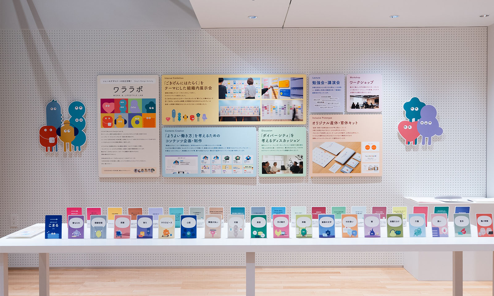 （ALT始まり）カラフルなキャラクターや写真が印刷されたパネルが壁に展示されている。（ALT終わり）