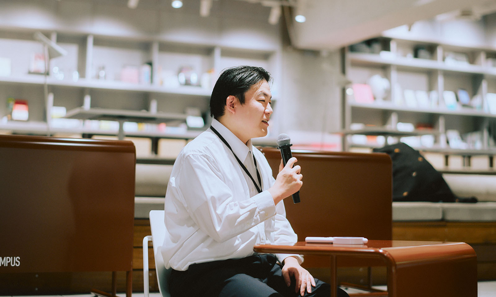 ALTはじまり。前髪を上げておでこを出すようなヘアスタイルで、白い襟付きシャツを着ている登壇者の田中さん。座りながら柔らかい表情でマイクを持って話している。ALTおわり。