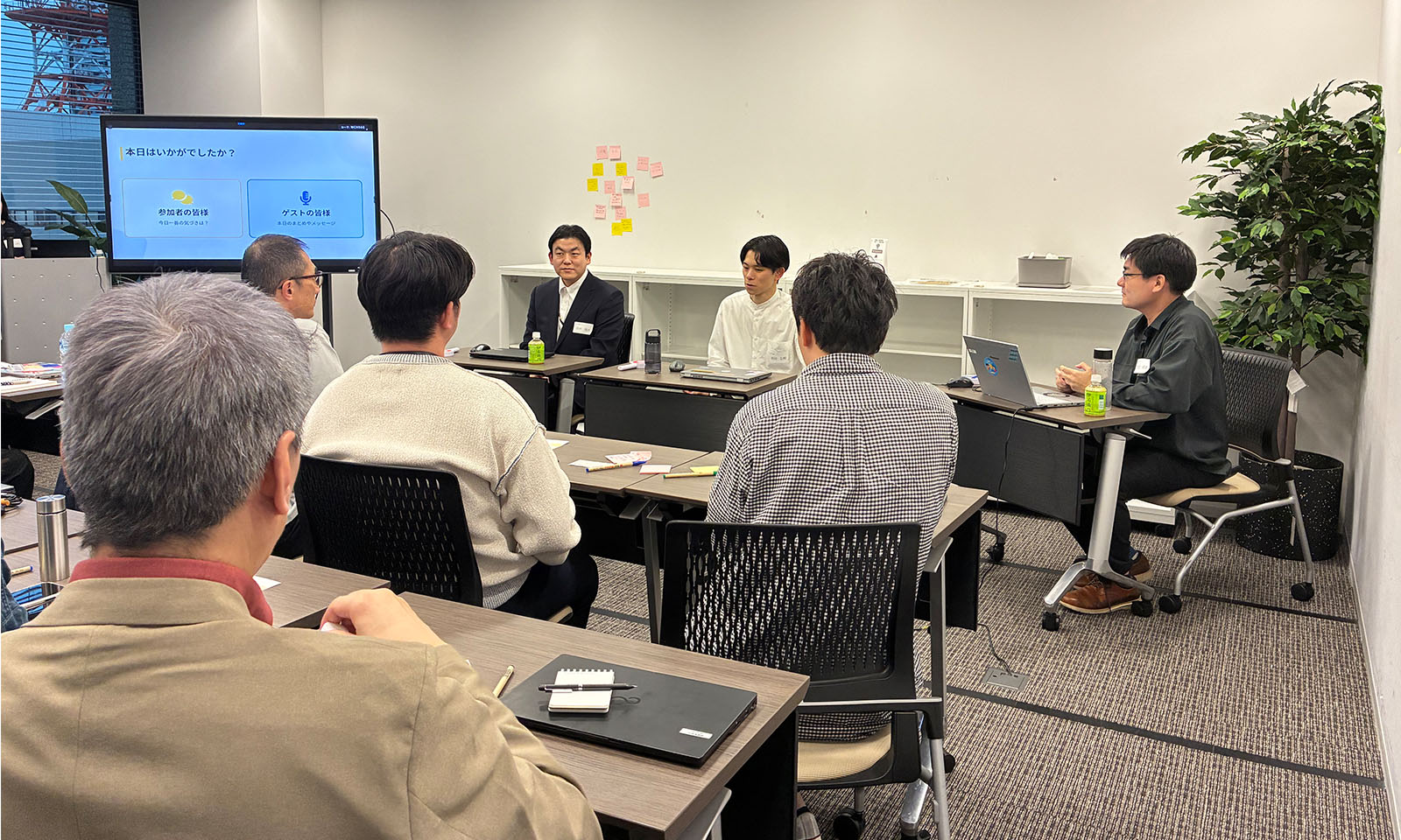 ALTはじまり。会議室の前方で3人が登壇している。左からジャケットを着用の田中さん、白いシャツの前田さん、チャコールグレーのシャツの太田さん。聴講する社員の後姿も。ALTおわり。