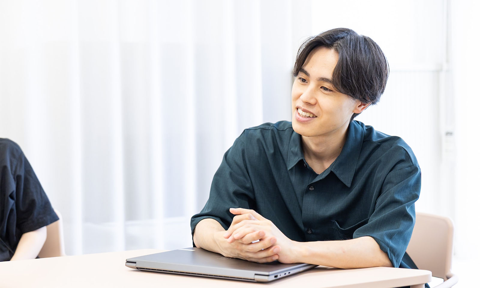 ALTはじまり。画像：インタビュー中の佐々木さん。黒っぽいシャツを着た男性。画像おわり。ALTおわり。