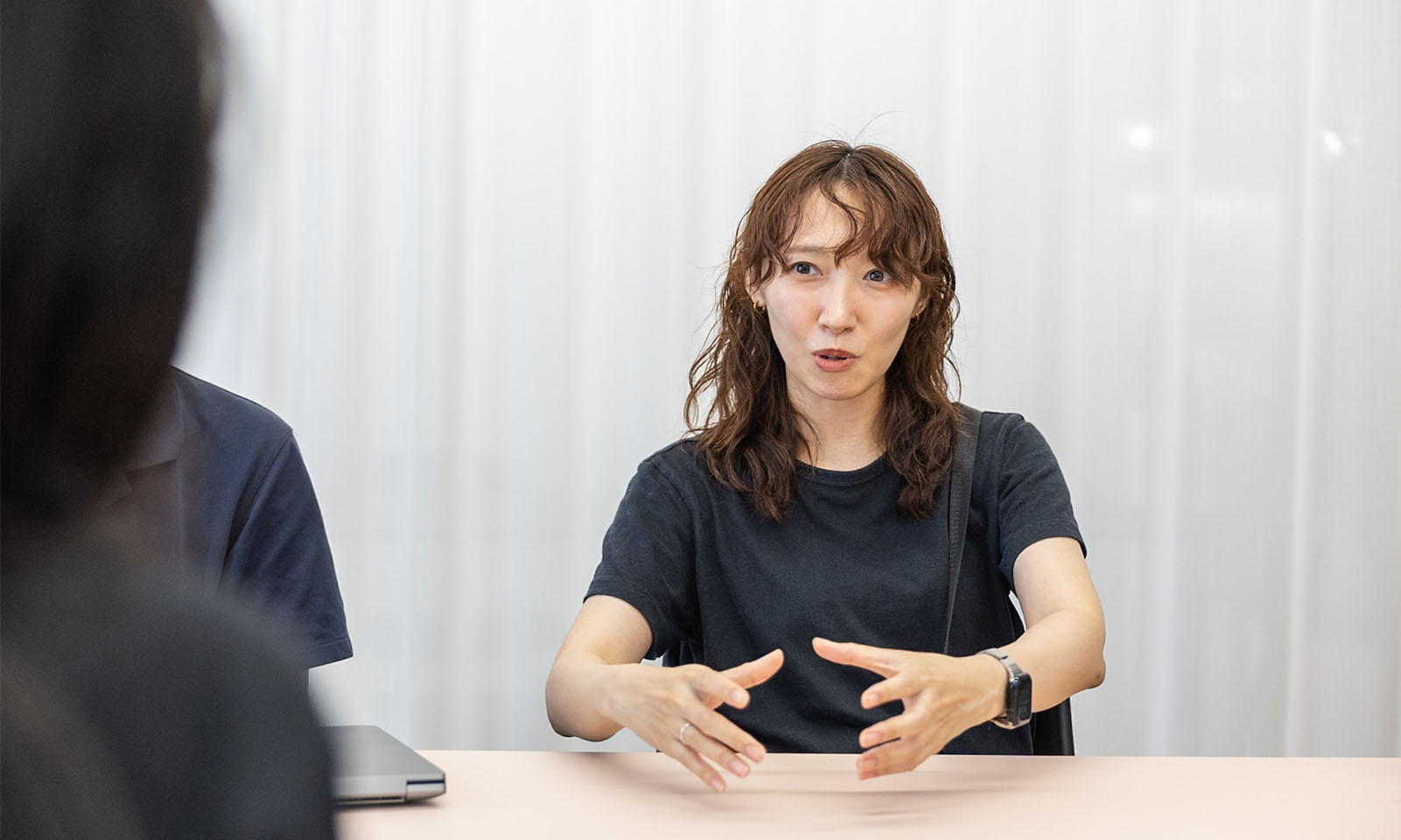 ALTはじまり。画像：インタビュー中の羽場さん。黒いTシャツを着ている女性。画像おわり。ALTおわり。